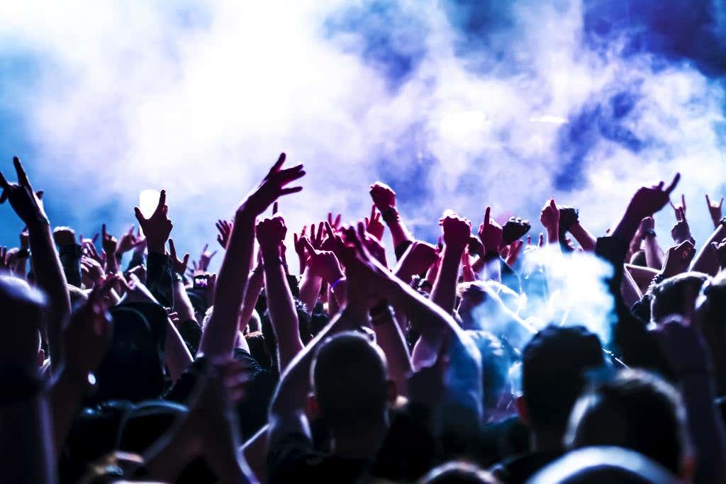 silhouettes of concert crowd in front of bright stage lights