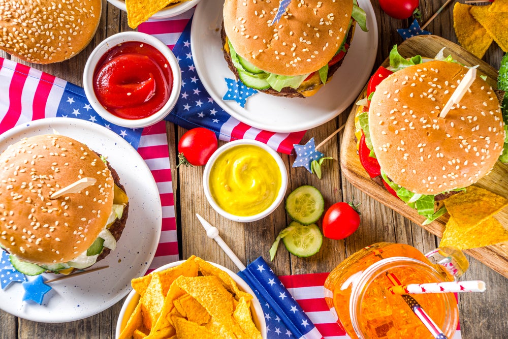 Patriotic Picnic with burgers, french fries and snacks, Summer USA picnic and bbq concept, Old wooden background